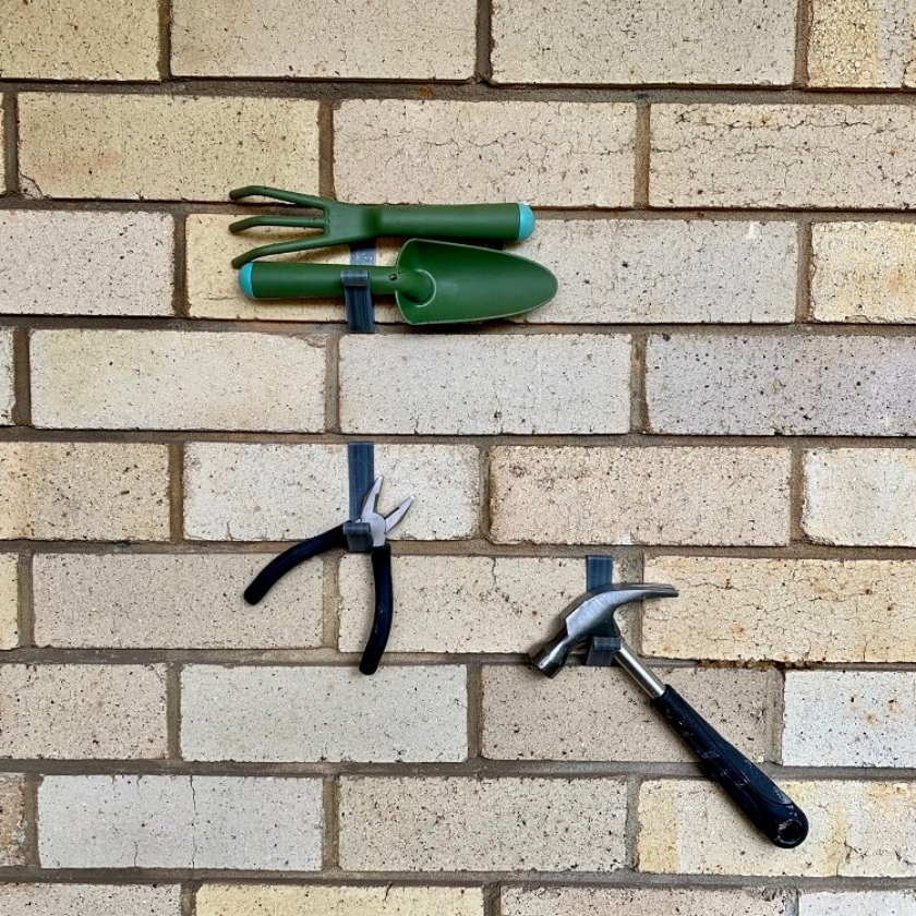Home equipment is hung on a brick wall with a Brick Grip Special to make it easier to find the items you need for your home's decor.