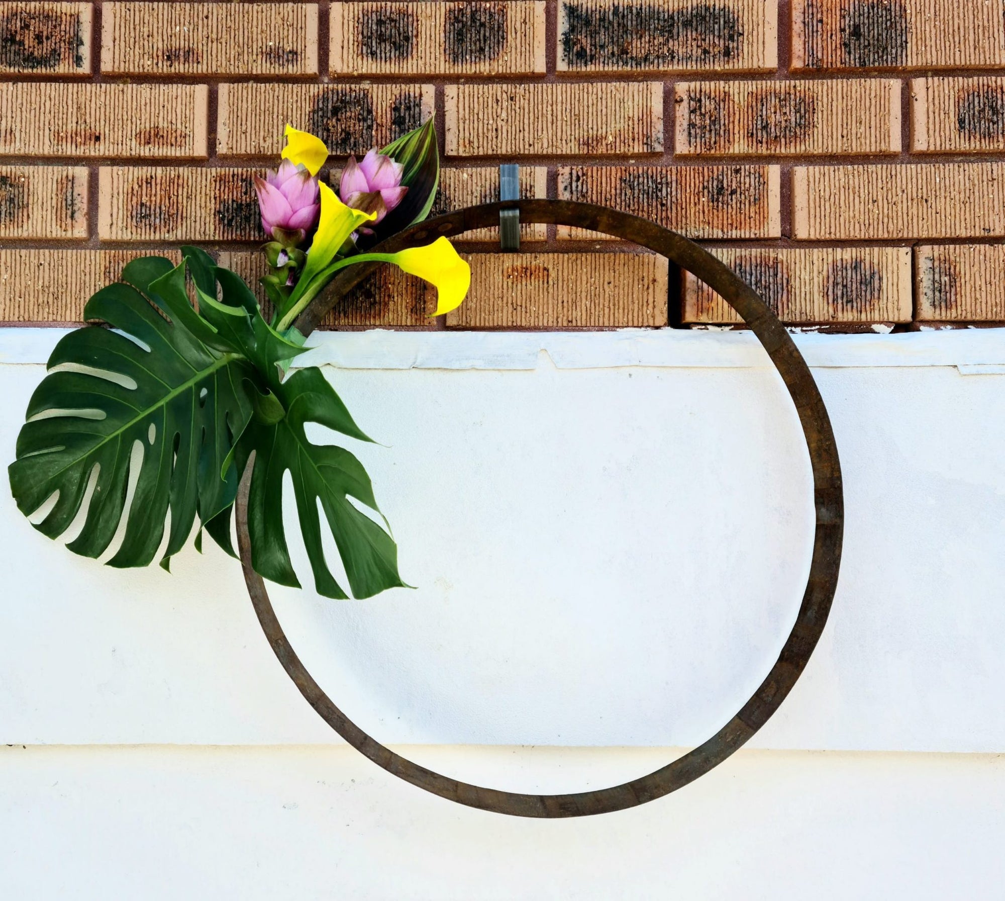 Brick wall with a brick hook hanging the flower leaves circle decoration