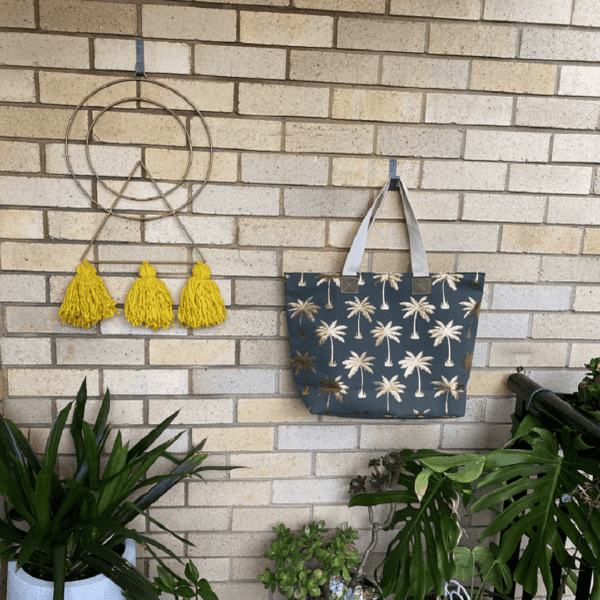 Beautiful bag and wall decoration hanging on the brick hook with plants on the floor