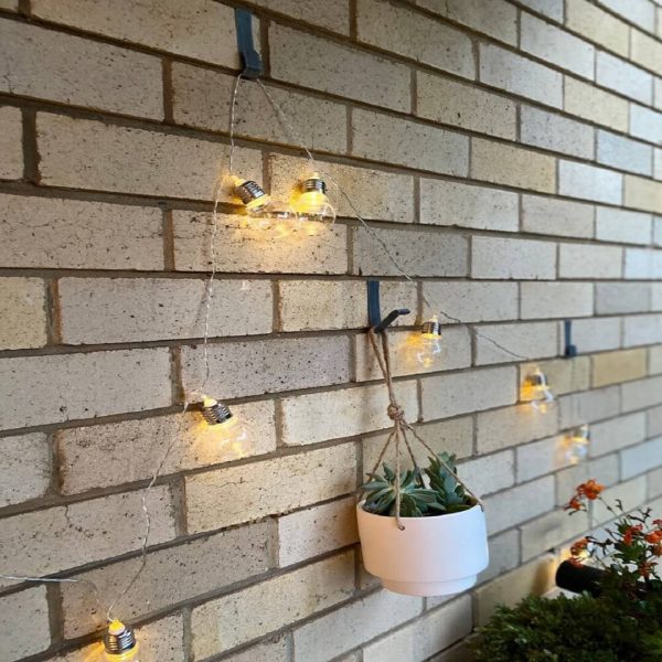 String lights and plants hanging on the brick hook