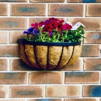 Brick wall with a hanging iron flower vase